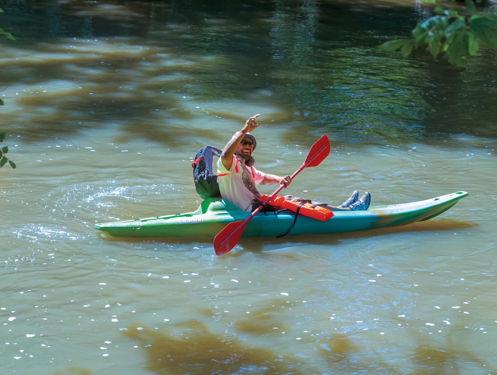 Man waving in his kayak on the White River between Yorktown and Daleville, Indiana Canoes and kayaks are rented through Canoe Country Rentals in Daleville, Indiana.